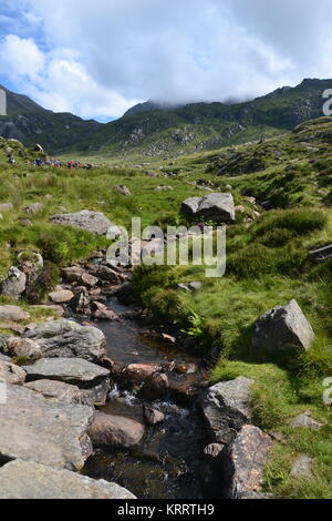 Gruppo di escursionisti sul monte Tryfan a piedi in direzione di Llyn Ogwen Foto Stock