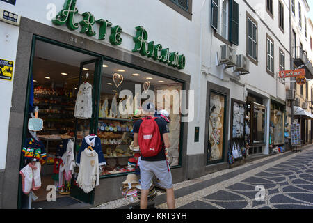 Giovane uomo alla ricerca di un negozio di souvenir finestra, Funchal, Madeira, Portogallo Foto Stock