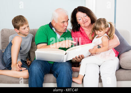Nonni e nipoti Guardando Album di foto Foto Stock