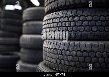 Pneumatici per la vendita in un negozio di pneumatici - pile di vecchi pneumatici usati Foto Stock