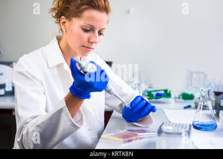 Ritratto di un ricercatore femmina svolgendo attività di ricerca in un laboratorio di chimica (colore immagine dai toni shallow DOF) Foto Stock