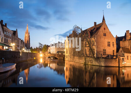 Bruges, Belgio - 17 Aprile 2017: Dock del Rosario - Rozenhoedkaai e Belfry al crepuscolo. La scena di una fiaba medievale di Bruges, Belgio Foto Stock