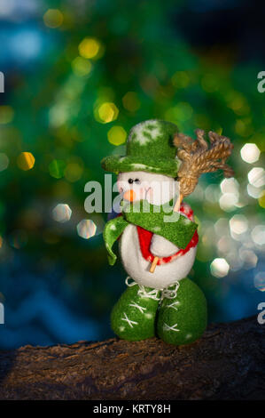 Pupazzo di neve con una scopa su uno sfondo sfocato albero di Natale Foto Stock