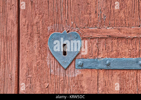 Cuore di ferro a forma di serratura sul vecchio ruvida porta in legno Foto Stock