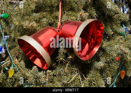 Rosso campana di Natale ornamento su albero di Natale con le luci di Natale Foto Stock