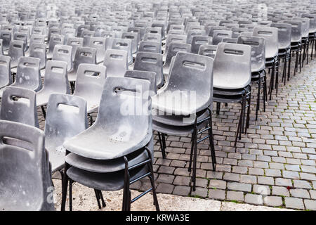 Molti vecchi vuoto sedie di plastica sulla piazza urbana Foto Stock