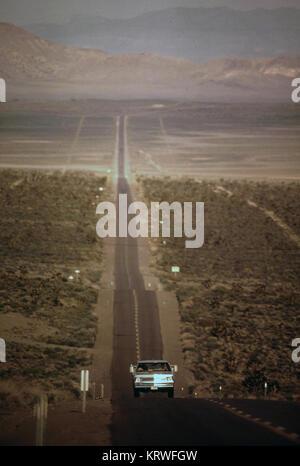 Pickup truck sulla strada desolata nel deserto del Nevada in 1972 Foto Stock