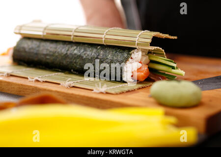 Mata bambusowa, przygotowywanie sushi. Jak przygotowaÄ‡ sushi. SkrÄ™canie rolki sushi w matÄ™ bambusowÄ… Foto Stock