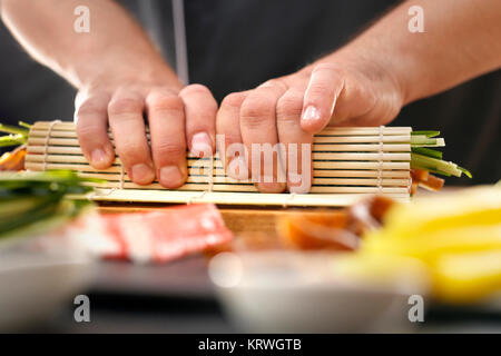 Mata bambusowa, przygotowywanie sushi. Jak przygotowaÄ‡ sushi. SkrÄ™canie rolki sushi w matÄ™ bambusowÄ… Foto Stock
