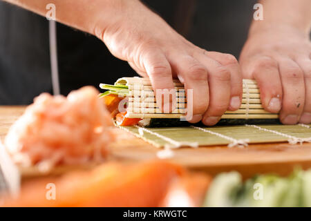 Mata bambusowa, przygotowywanie sushi. Jak przygotowaÄ‡ sushi. SkrÄ™canie rolki sushi w matÄ™ bambusowÄ… Foto Stock