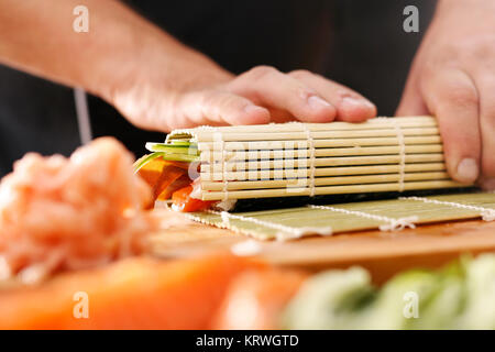 Mata bambusowa, przygotowywanie sushi. Jak przygotowaÄ‡ sushi. SkrÄ™canie rolki sushi w matÄ™ bambusowÄ… Foto Stock