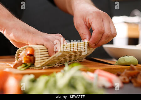 Mata bambusowa, przygotowywanie sushi. Jak przygotowaÄ‡ sushi. SkrÄ™canie rolki sushi w matÄ™ bambusowÄ… Foto Stock