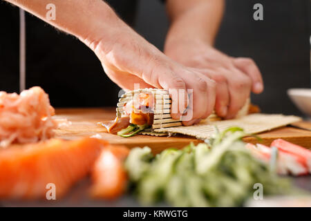 Mata bambusowa, przygotowywanie sushi. Jak przygotowaÄ‡ sushi. SkrÄ™canie rolki sushi w matÄ™ bambusowÄ… Foto Stock