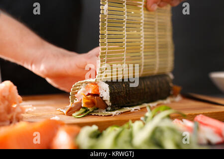 Mata bambusowa, przygotowywanie sushi. Jak przygotowaÄ‡ sushi. SkrÄ™canie rolki sushi w matÄ™ bambusowÄ… Foto Stock