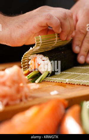 Mata bambusowa, przygotowywanie sushi. Jak przygotowaÄ‡ sushi. SkrÄ™canie rolki sushi w matÄ™ bambusowÄ… Foto Stock