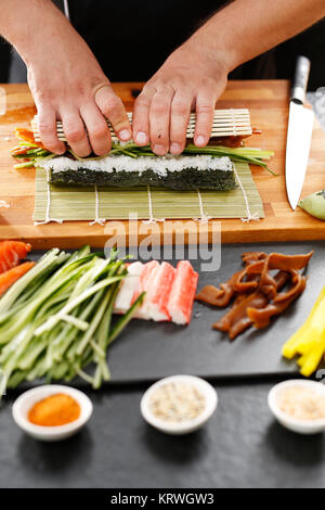 Mata bambusowa, przygotowywanie sushi. Jak przygotowaÄ‡ sushi. SkrÄ™canie rolki sushi w matÄ™ bambusowÄ… Kurs przygotowywania sushi Foto Stock