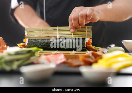 Mata bambusowa, przygotowywanie sushi. Jak przygotowaÄ‡ sushi. SkrÄ™canie rolki sushi w matÄ™ bambusowÄ… Kurs przygotowywania sushi Foto Stock