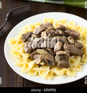 Carni bovine Stroganoff sulle farfalle di pasta Foto Stock