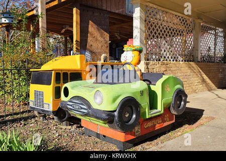Vecchio scartato i bambini di giostre, Garfield auto e un giallo camion dei pompieri, sedersi abbandonato dietro chiusa alle aziende in un ambiente rurale città della Georgia, Stati Uniti d'America. Foto Stock