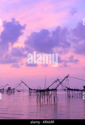 Silhouette a rete da pesca trappola a sunrise seascape in Phatthalung, Thailandia Foto Stock