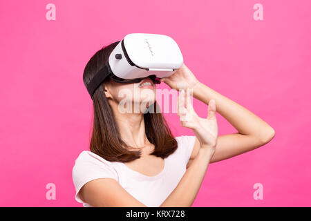 Giovane donna giocando con dispositivo VR Foto Stock