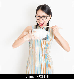 Ragazza orientale di mangiare con bacchette Foto Stock