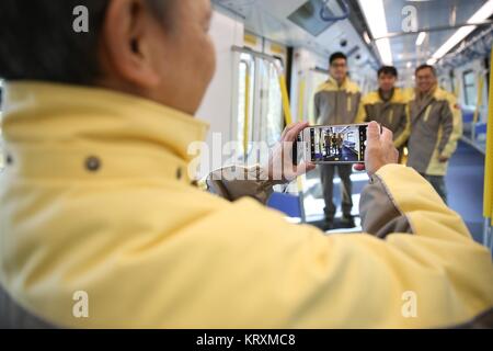 Qingdao, Cina Shandong. Xxi Dec, 2017. I membri dello staff di Hong Kong MTR corporation posano per una foto di gruppo in cabina di un nuovo treno della metropolitana a CRRC Qingdao Sifang Company a Qingdao, Cina orientale della provincia di Shandong, 21 dicembre 2017. Il treno della metropolitana, che possiedono i più alti standard internazionali per la sicurezza antincendio, è uscito dalla linea di assemblaggio a Qingdao giovedì. Il treno è stato sviluppato per le linee in centro a Hong Kong, Cina del sud. Credito: Zhang Jingang/Xinhua/Alamy Live News Foto Stock