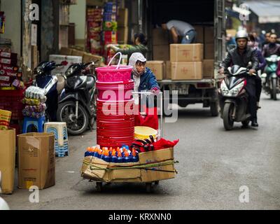 Hanoi, Hanoi, Vietnam. 22 Dic, 2017. Una donna spinge il suo carrello di merci secche che lei vende sulle strade del quartiere antico di Hanoi. Il vecchio quartiere è il cuore di Hanoi, con strade strette e molti piccoli negozi ma è in corso di ''gentrified'' a causa del turismo e alcuni dei negozi sono trasformate in alberghi e caffè per i turisti e per i ricchi vietnamita. Credit: Jack Kurtz/ZUMA filo/Alamy Live News Foto Stock