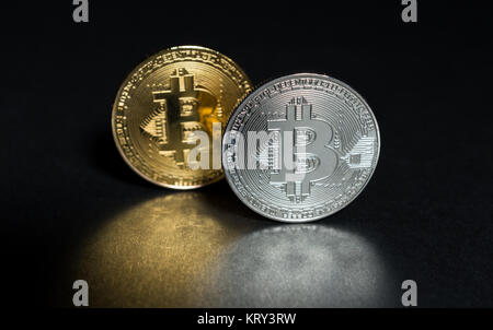 Due bitcoins golden e silver isolato scuro su sfondo nero con bella riflessione Foto Stock