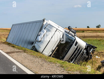 Il grande camion giace in un fosso laterale dopo l'incidente stradale. Foto Stock