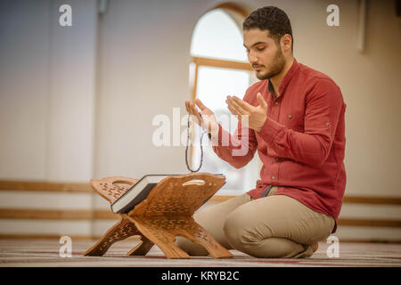 Religiosa musulmana uomo che prega all'interno della moschea Foto Stock