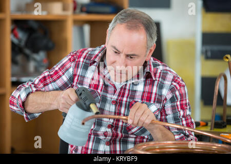 Lavoratore con cannello per la saldatura di raccordi in rame Foto Stock