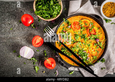 Il cibo indiano ricette, Masala frittata con verdure fresche - pomodoro, peperoncino, prezzemolo, pietra scura, sfondo spazio copia vista superiore Foto Stock