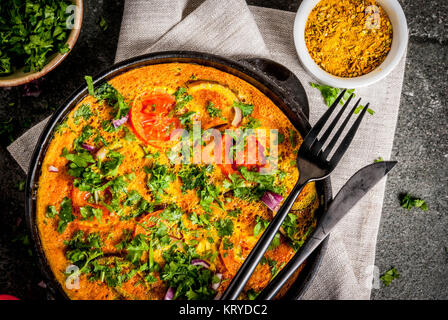 Il cibo indiano ricette, Masala frittata con verdure fresche - pomodoro, peperoncino, prezzemolo, pietra scura, sfondo spazio copia vista superiore Foto Stock