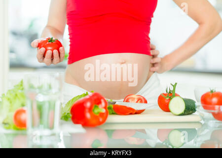 Schwangere Frau mit Gemüse - donna incinta con verdure Foto Stock