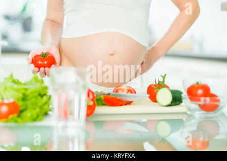 Schwangere Frau mit Gemüse - donna incinta con verdure Foto Stock