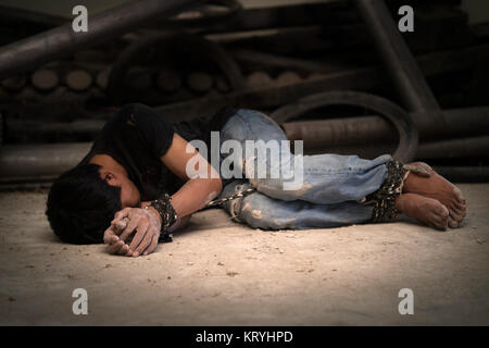 Uomo disperata mani legate insieme con fune Foto Stock