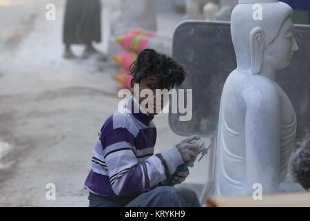 Scene di pietra-muratori alacremente il taglio e la lucidatura del marmo nei laboratori di Mandalay. Foto Stock