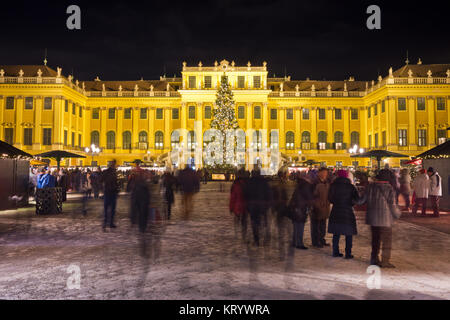 Vista illumina il castello di Schönbrunn in tempo di Natale con le luci fairy albero di Natale decorato al crepuscolo in Avvento. Foto Stock