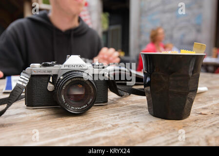 Un vecchio 35mm SLR Fotocamera film seduto su una tabella in un coffee shop Foto Stock