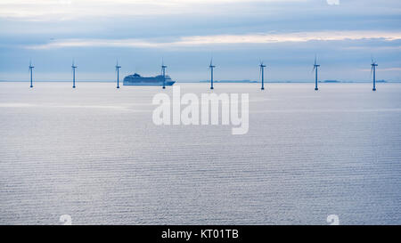 Traghetto nei pressi del parco eolico offshore in mattinata al crepuscolo Foto Stock