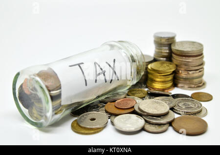 Etichetta fiscale in un vasetto di vetro con monete fuoriuscita Foto Stock
