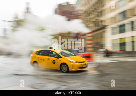 Una panoramica di un giallo taxi guidando lungo una strada di Lower Manhattan, New York, Stati Uniti d'America Foto Stock