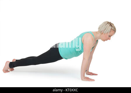 Ganzkörper-Ansicht einer jungen blondn Frau bei Yoga-Übungen vor weißen Hintergrund mit leichtem Schatten Foto Stock