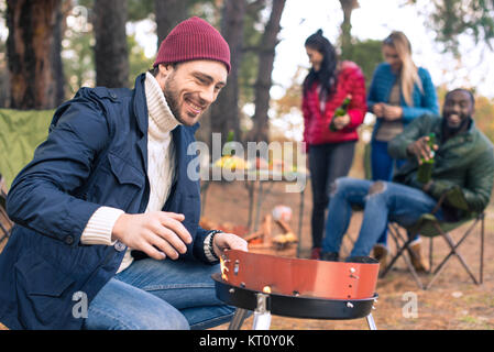 L'uomo facendo accendere il fuoco sul grill Foto Stock