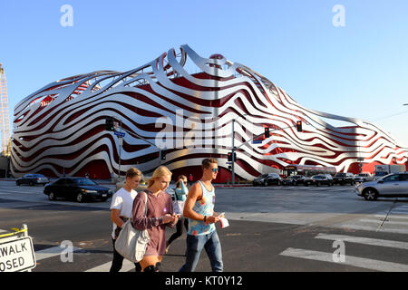 Un gruppo di giovani turisti adolescenti camminando lungo il Wilshire Blvd. Passato Petersen Automotive Museum edificio di Los Angeles, California USA KATHY DEWITT Foto Stock