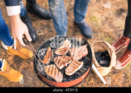 La gente la cottura della carne sulla griglia a carbone Foto Stock