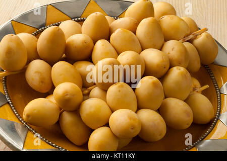 Mazzetto di fresco date giallo su un piatto mediterraneo Foto Stock