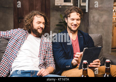 Amici utilizzando la tavoletta digitale Foto Stock