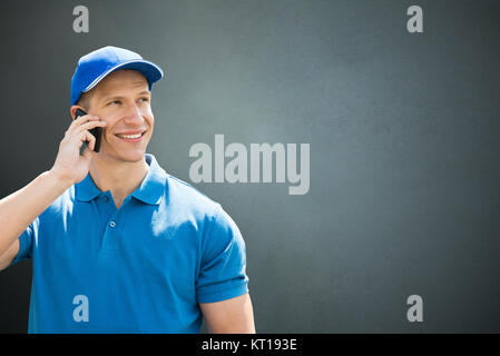 Consegna maschio uomo parlando al cellulare Foto Stock
